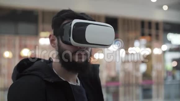 在购物中心使用虚拟现实护目镜的年轻人视频的预览图