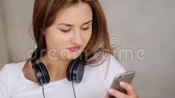 快乐迷人的女人用耳机听音乐在白色背景下跳舞视频的预览图