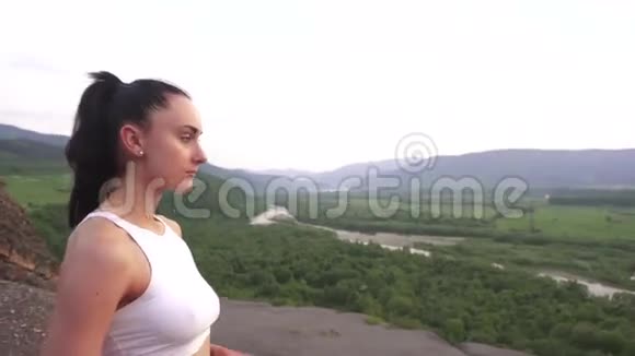 运动员女子运动服饮用水户外训练后青山景观背景视频的预览图