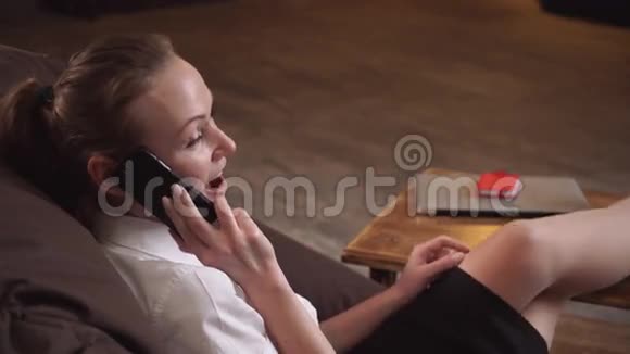 女人坐在椅子上打电话视频的预览图