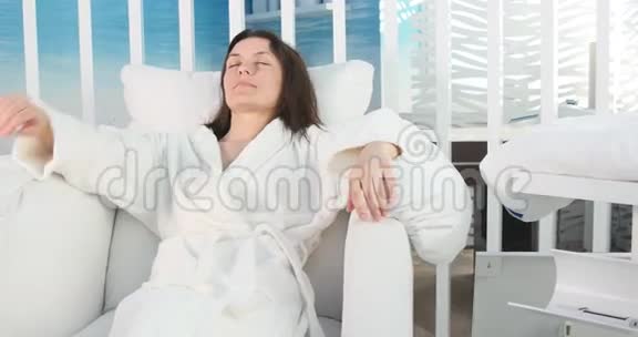 美丽的女人在水疗沙龙里穿着浴袍放松视频的预览图