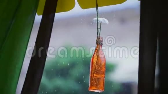 棕色瓶子里面有洋甘菊瓶子挂在线上窗外的雨视频的预览图