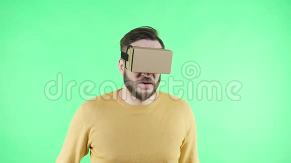 男人享受纸板谷歌VR耳机的电话视频的预览图