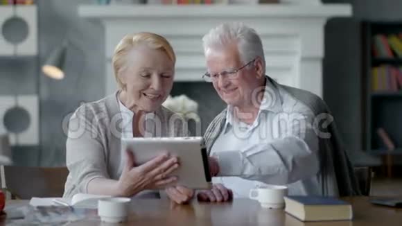 快乐可爱的退休夫妇使用平板电脑开怀大笑视频的预览图