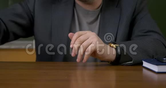 老师拿着记录本坐在桌旁视频的预览图
