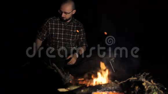 一个人在篝火旁用平板电脑视频的预览图