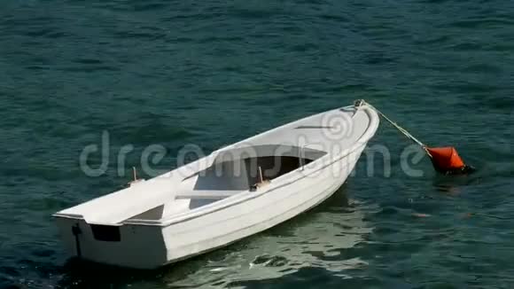 走近一艘白色木船水面上有橙色的浮标视频的预览图