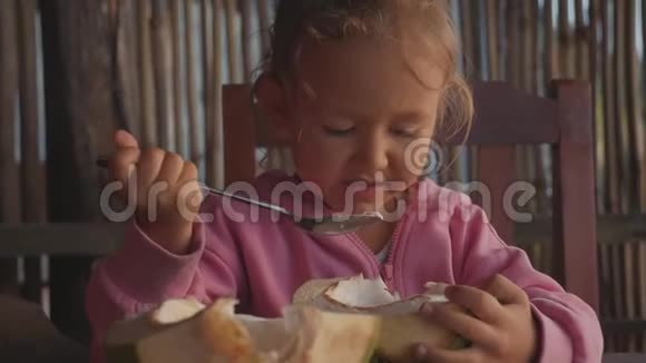 小可爱的女孩在咖啡馆里慢吞吞地吃椰子视频的预览图