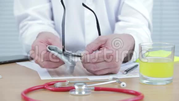 医生在他的桌子上擦眼镜视频的预览图