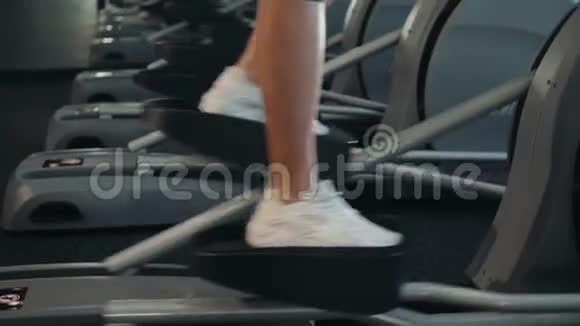 美丽的健身女性在有氧运动机上锻炼健身女性锻炼双手腿走路视频的预览图