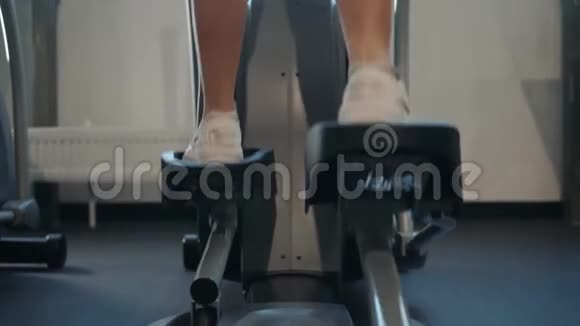美丽的健身女性在有氧运动机上锻炼健身女性锻炼双手腿走路视频的预览图