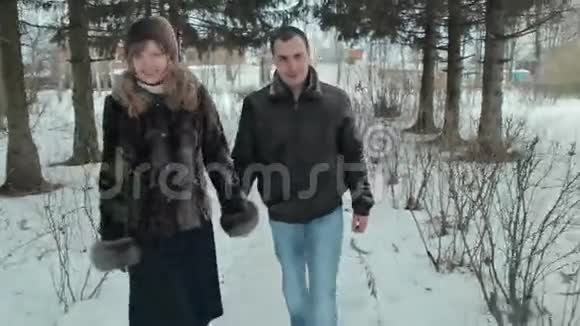 年轻快乐的一对在冬季公园散步视频的预览图