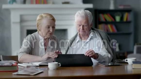 快乐的老人男人和女人使用电脑他们把它关上互相看着视频的预览图