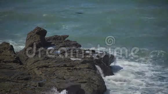 月光石滩海滩附近的岩石上溅起波浪视频的预览图
