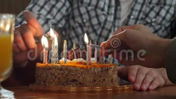 两只手在生日蛋糕上点燃蜡烛视频的预览图