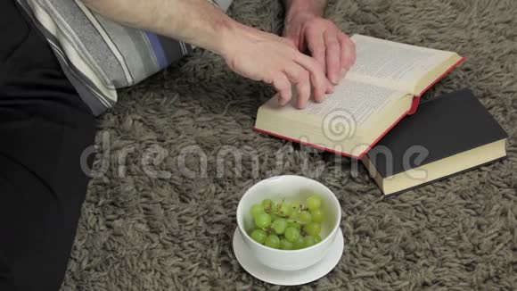 躺在地毯上看书擦眼镜的人视频的预览图