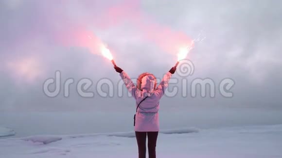 一个人站在金属码头附近冬天举着红色的烟羽4k20视频的预览图