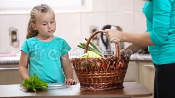 女孩帮妈妈从篮子里拉蔬菜视频的预览图
