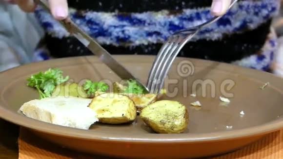 手切烤土豆在盘子里刀叉在框架内视频的预览图