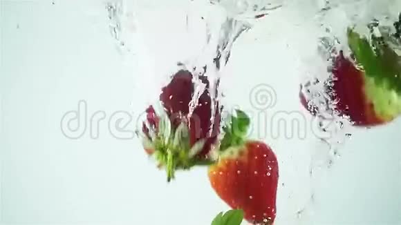 白色背景下超慢多种草莓溅入水中视频的预览图