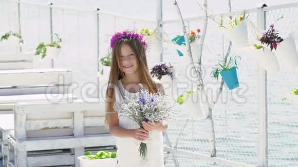 快乐聪明的女孩欣赏鲜花和微笑慢慢地视频的预览图