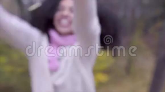快乐的黑人少女在树叶上打雨视频的预览图