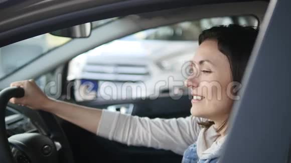 坐在车里听汽车中心推销员说话的漂亮女人缓调视频的预览图