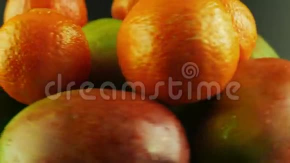 旋转芒果和橘子的大镜头黑色背景视频的预览图