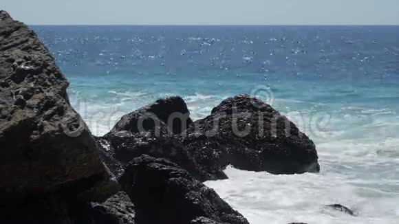 在Dume角阳光明媚的一天海浪撞击岩石的景象视频的预览图