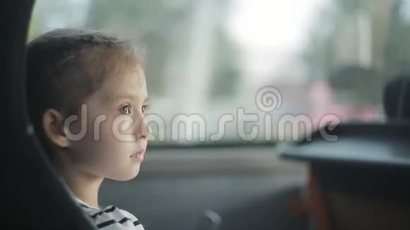 一个小女孩坐在窗边的公共汽车上视频的预览图