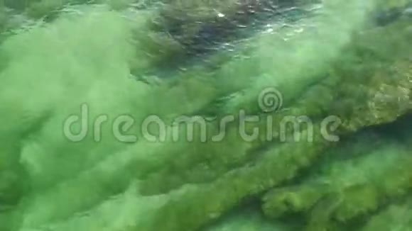 岩石海滩上美丽的翡翠海波视频的预览图