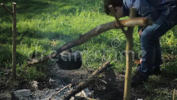 人在露营时把木头扔在火上清晨在森林里视频的预览图