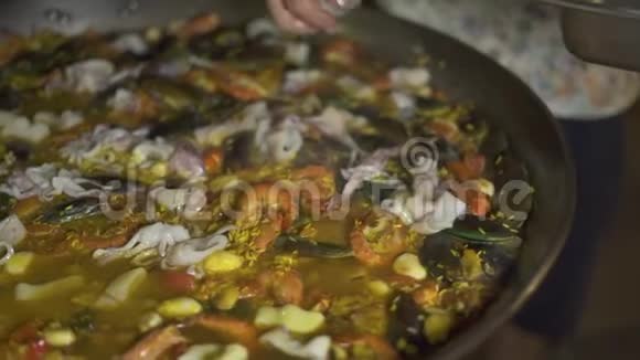 用米饭和新鲜海鲜在锅里煮西班牙海鲜饭传统西班牙菜饭视频的预览图