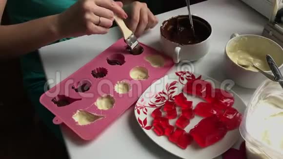 有刷子的女人用融化的黑巧克力润滑硅胶做甜点视频的预览图