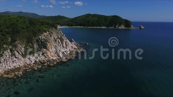 阳光明媚的一天沿着深蓝色的海岸线沿着一个戏剧性的悬崖边缘的空中拍摄视频的预览图