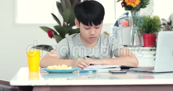 小亚洲青少年做家庭作业时面带微笑视频的预览图
