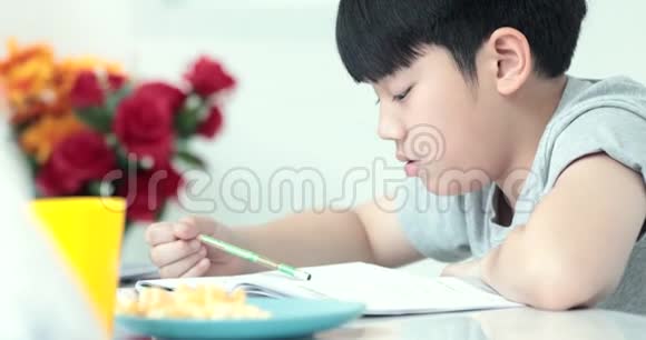 小亚洲青少年做家庭作业时面带微笑视频的预览图