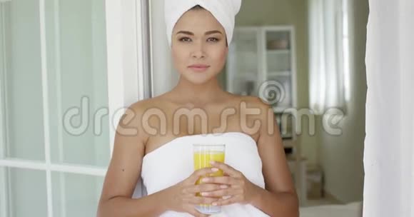 美丽的女人裹着毛巾看着外面视频的预览图