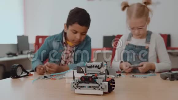 混合种族群体的学校孩子坐在课堂与DIY机器人茎教育的概念视频的预览图