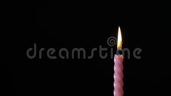 黑色背景上的单根粉红色条纹生日蜡烛视频的预览图