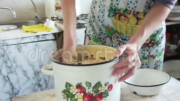 女厨子把面包揉在厨房的锅里视频的预览图