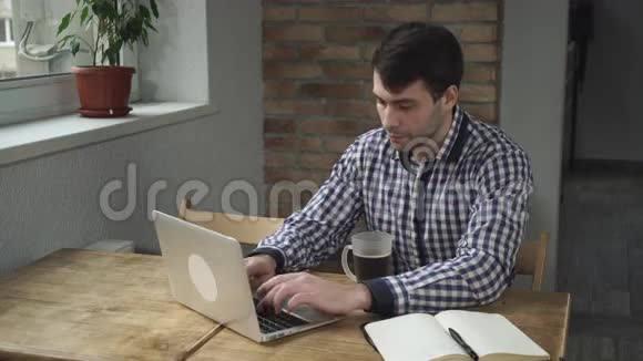 一个穿格子衬衫的人盯着显示器喝了一口咖啡视频的预览图