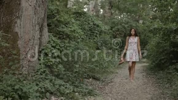 穿着裙子的布鲁内特赤脚走在路上视频的预览图