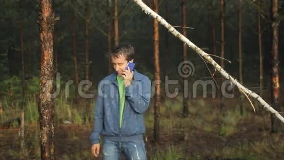 一个人在森林里的一棵树附近打电话清晨视频的预览图