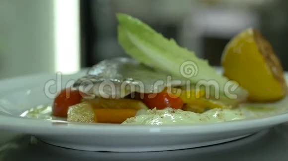 提供菜肴鱼和蔬菜餐厅内洒满奶酪柠檬视频的预览图