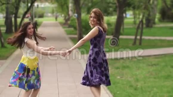 迷人的女孩穿过公园微笑女朋友花时间在户外明亮的夏天女孩视频的预览图