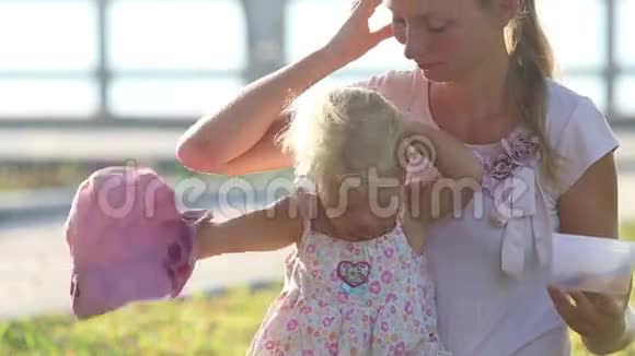 长发母亲和女儿坐在堤边的草坪上视频的预览图