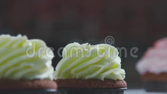 女人的手把一块巧克力放进奶油里纸杯蛋糕装饰视频的预览图