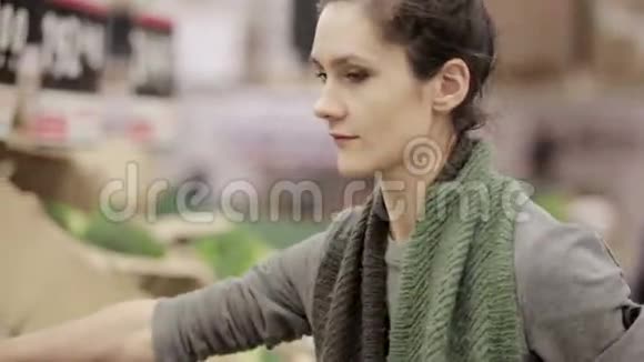 年轻女子在商店货架上选择卷心菜视频的预览图