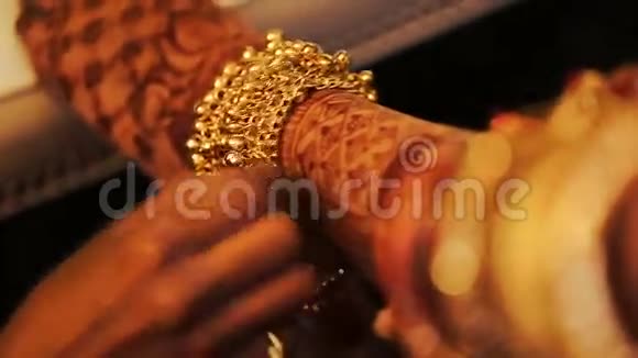 女人把金手镯放在印度新娘的腿上视频的预览图